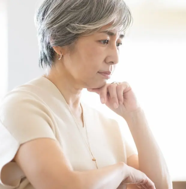 顎に手を当て考える女性